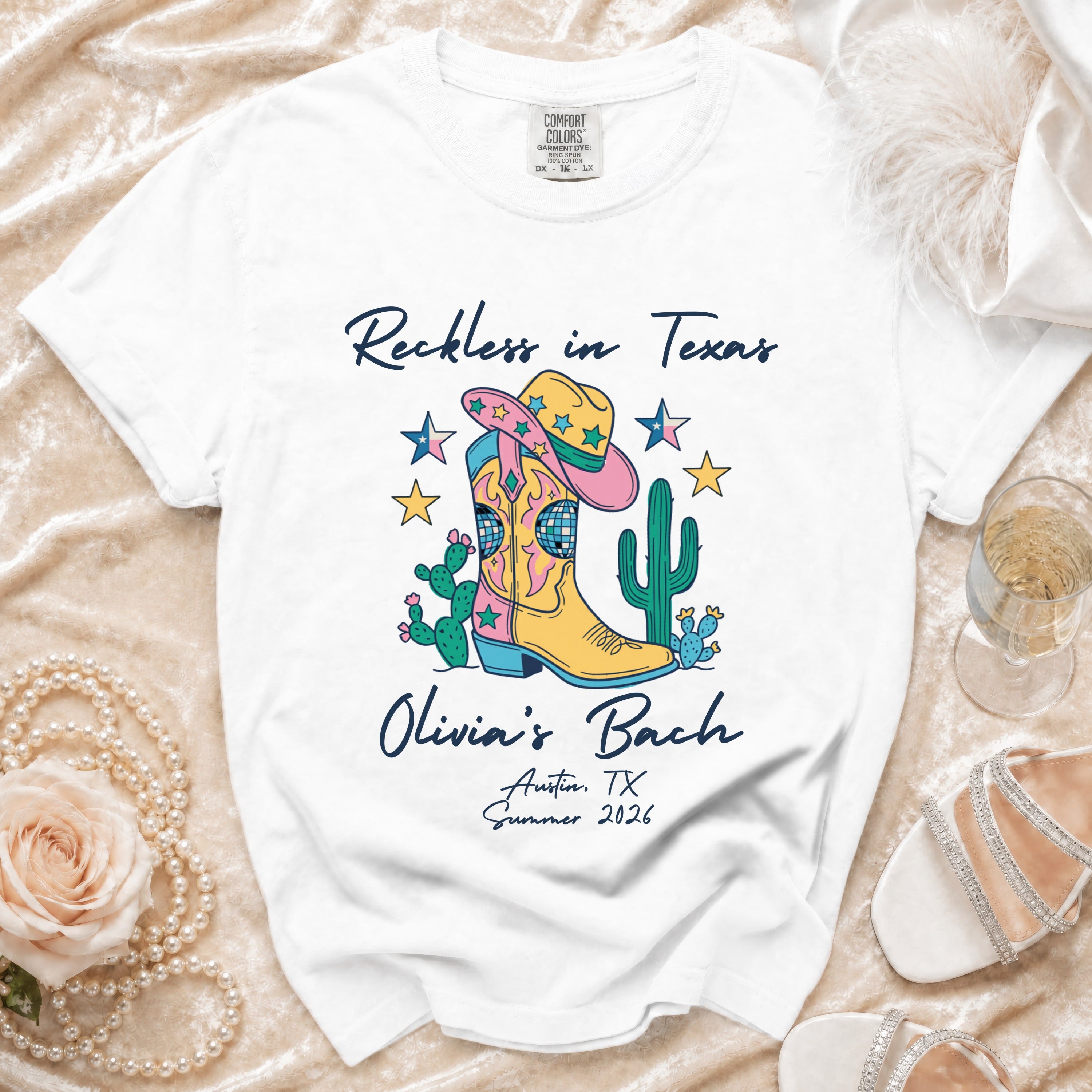 White t-shirt with "Reckless in Texas" and "Olivia's Bach" with Western graphics.