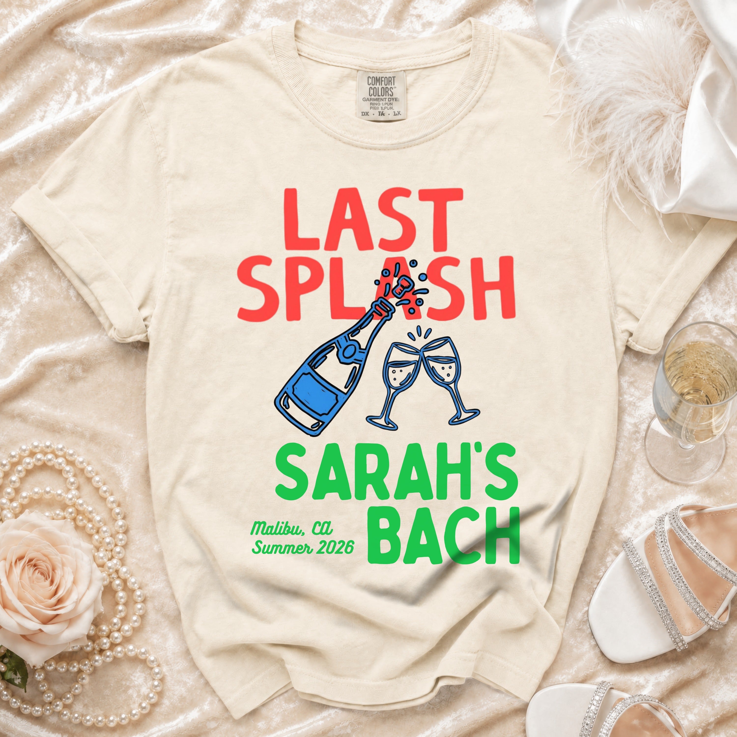 Cream t-shirt with "Last Splash Sarah's Bach Malibu, Ca Summer 2026" text and champagne glasses.