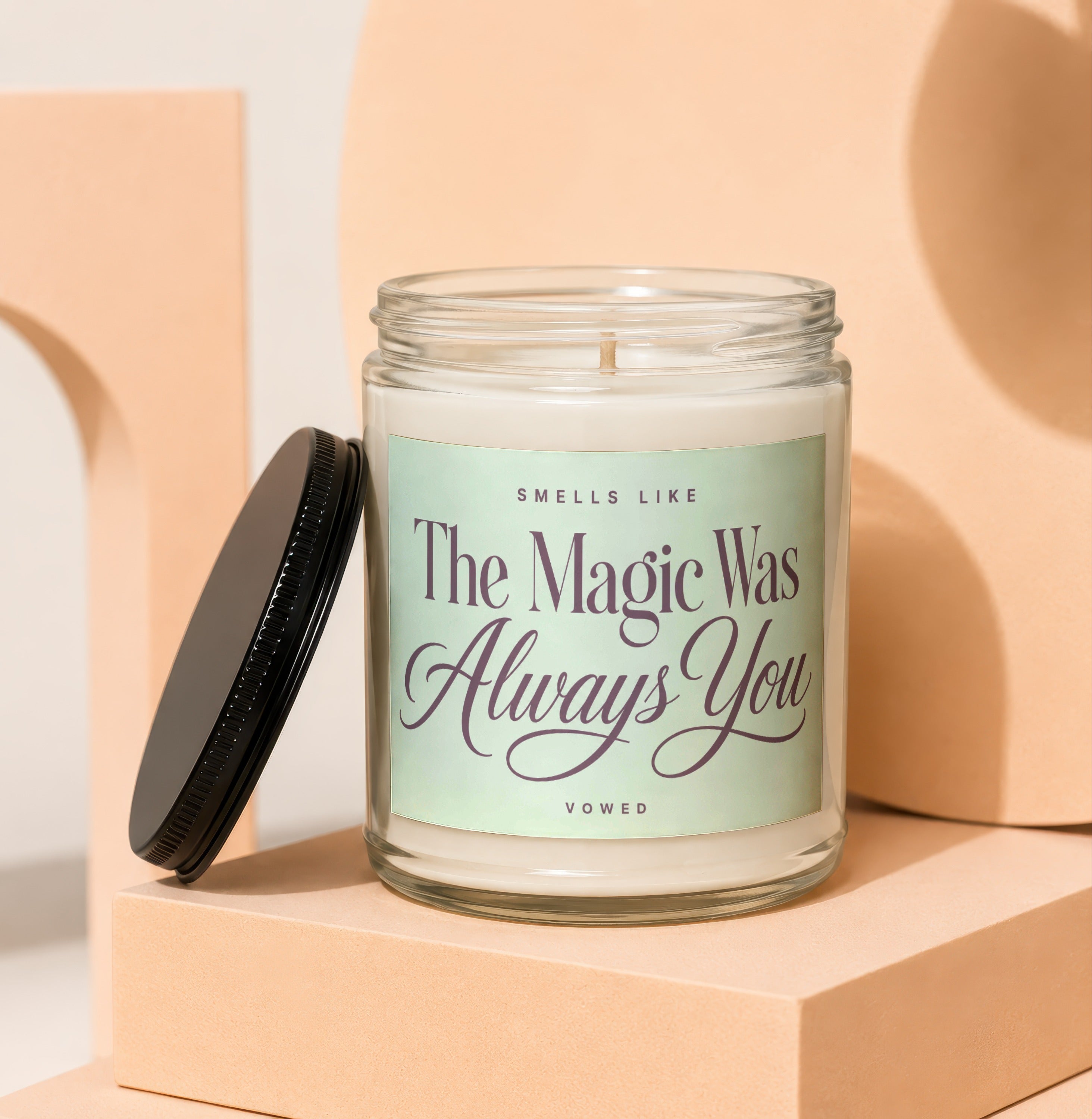 Glass candle with black lid, labeled "Smells like The Magic Was Always You", Vowed.