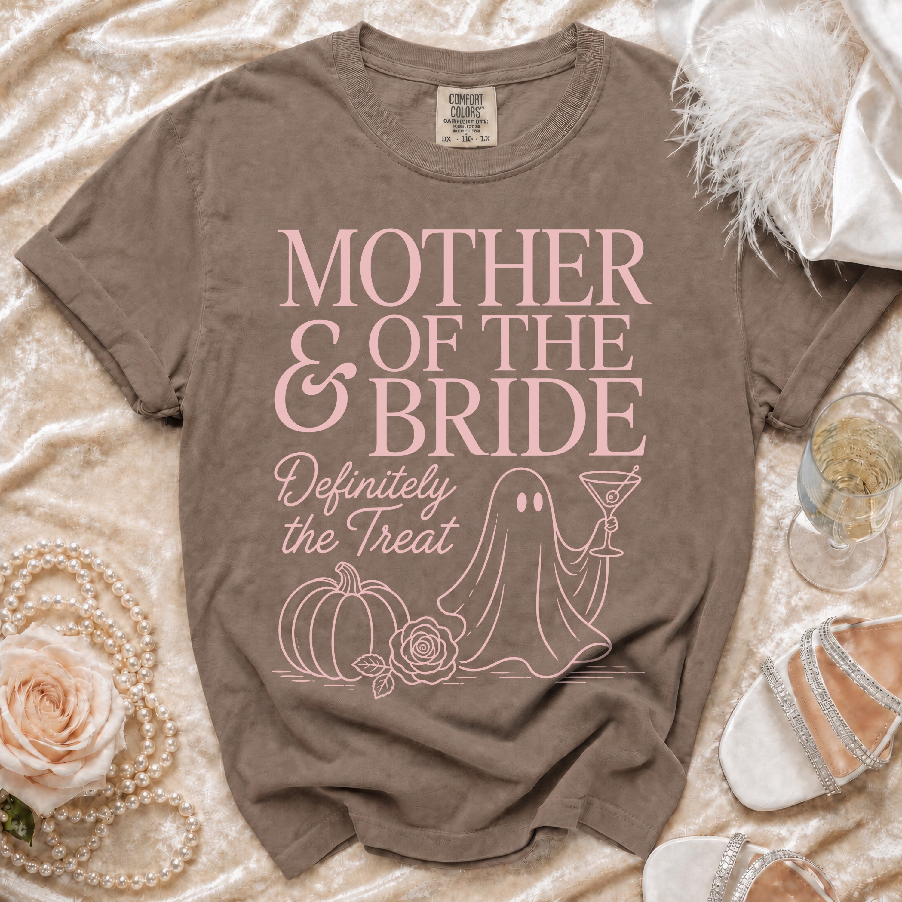 Brown t-shirt with pink text "Mother of the Bride Definitely the Treat" and graphics.