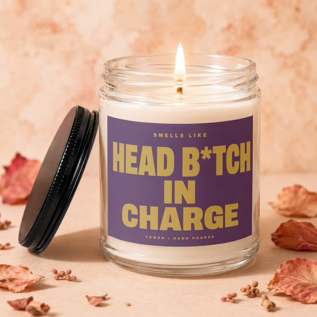 Candle with purple label reading "Smells Like Head B*tch In Charge"