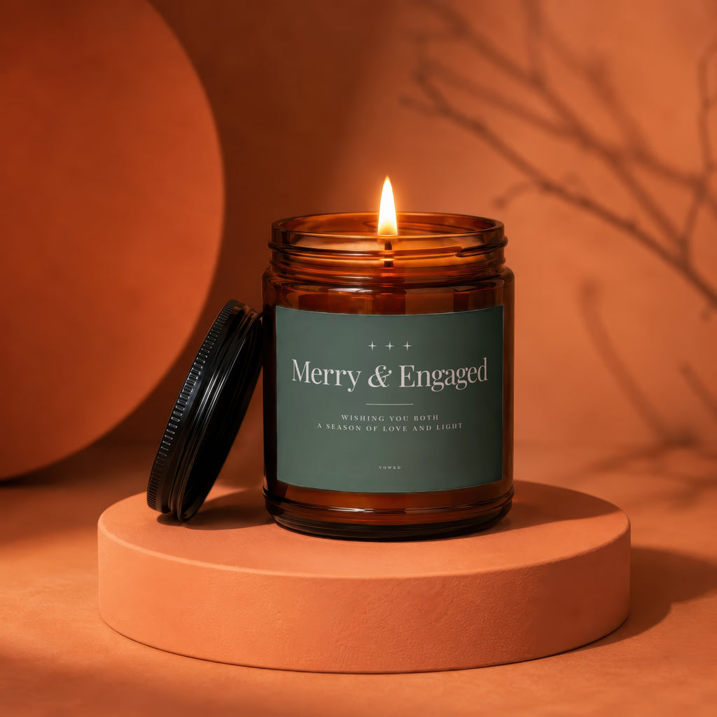 Amber jar candle with lit wick and "Merry & Engaged" label.