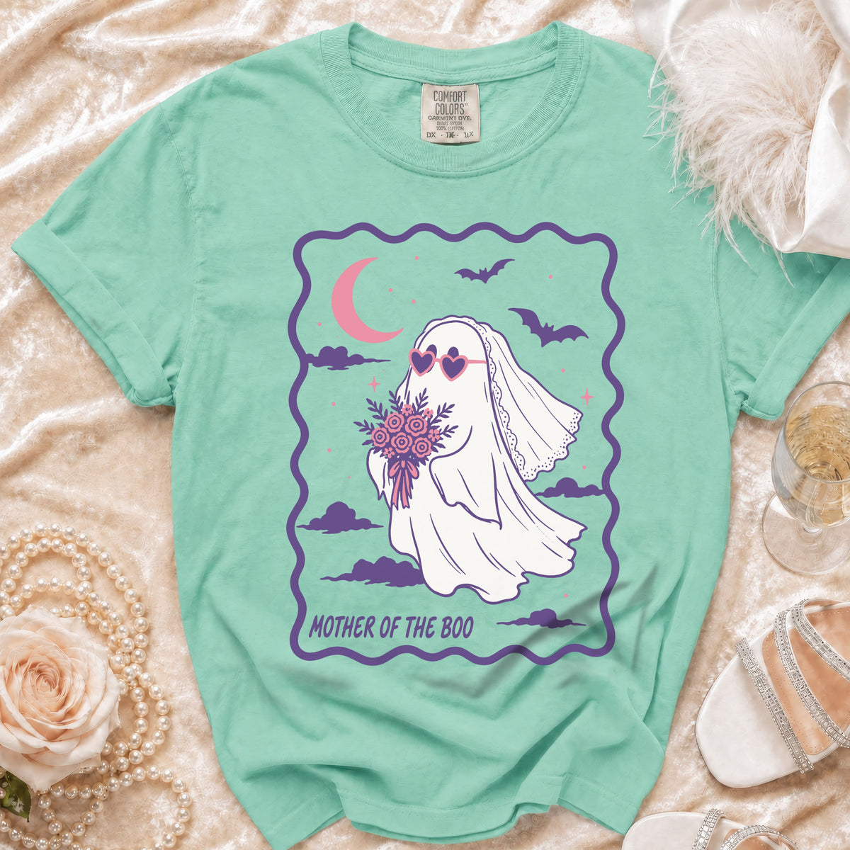 Mint green t-shirt with a ghost bride wearing heart sunglasses and holding flowers, text "MOTHER OF THE BOO".