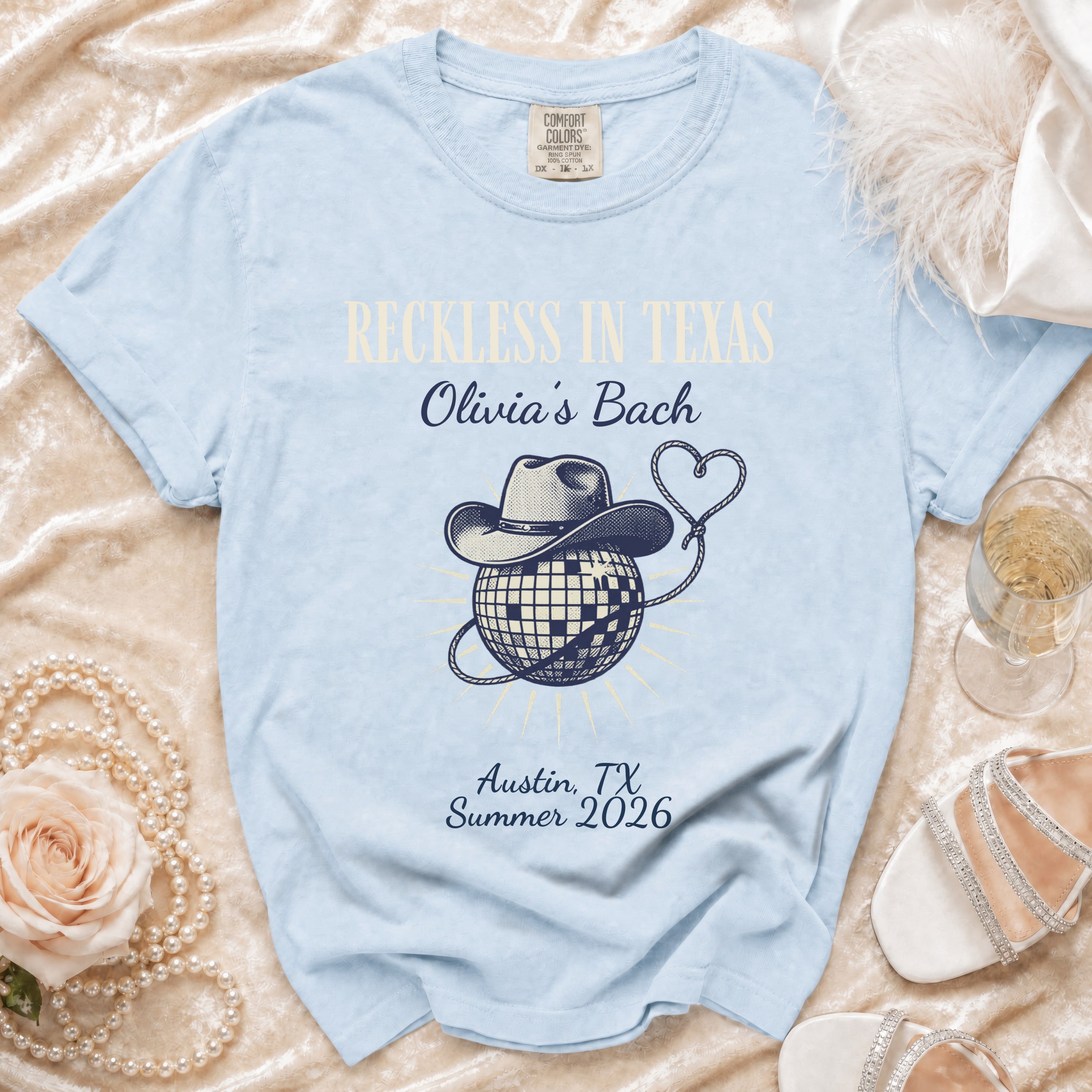 Light blue t-shirt with "Reckless in Texas Olivia's Bach" and disco ball graphic.