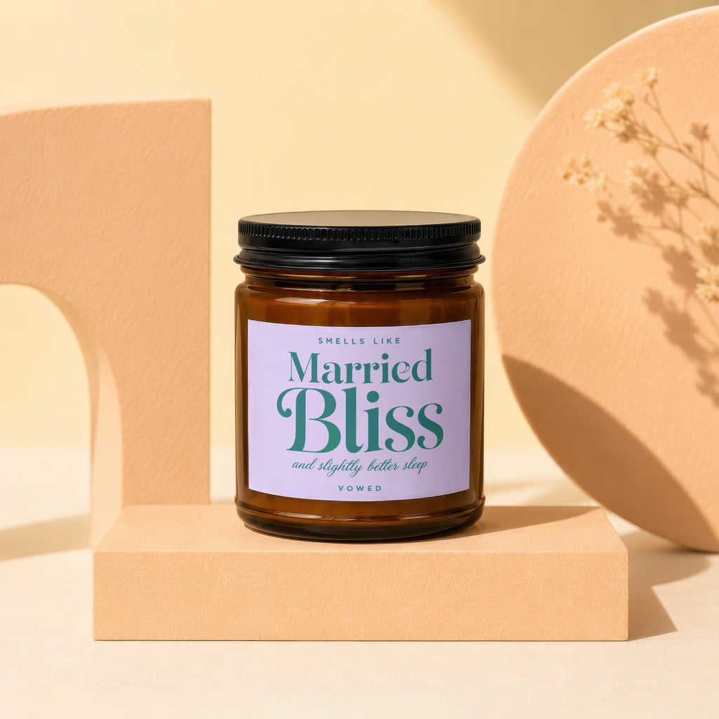 Amber jar candle labeled "Smells Like Married Bliss and Slightly Better Sleep" by Vowed.