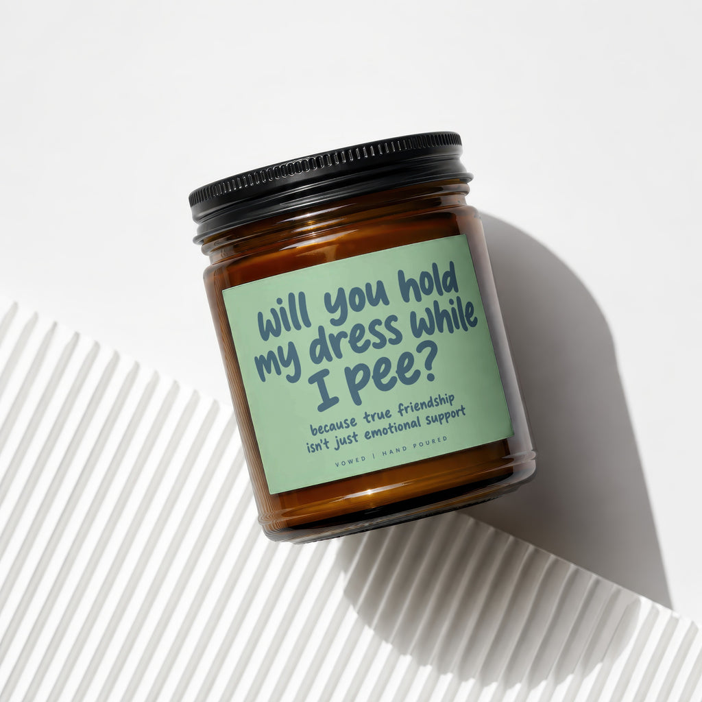 Amber candle with "will you hold my dress while I pee?" text.