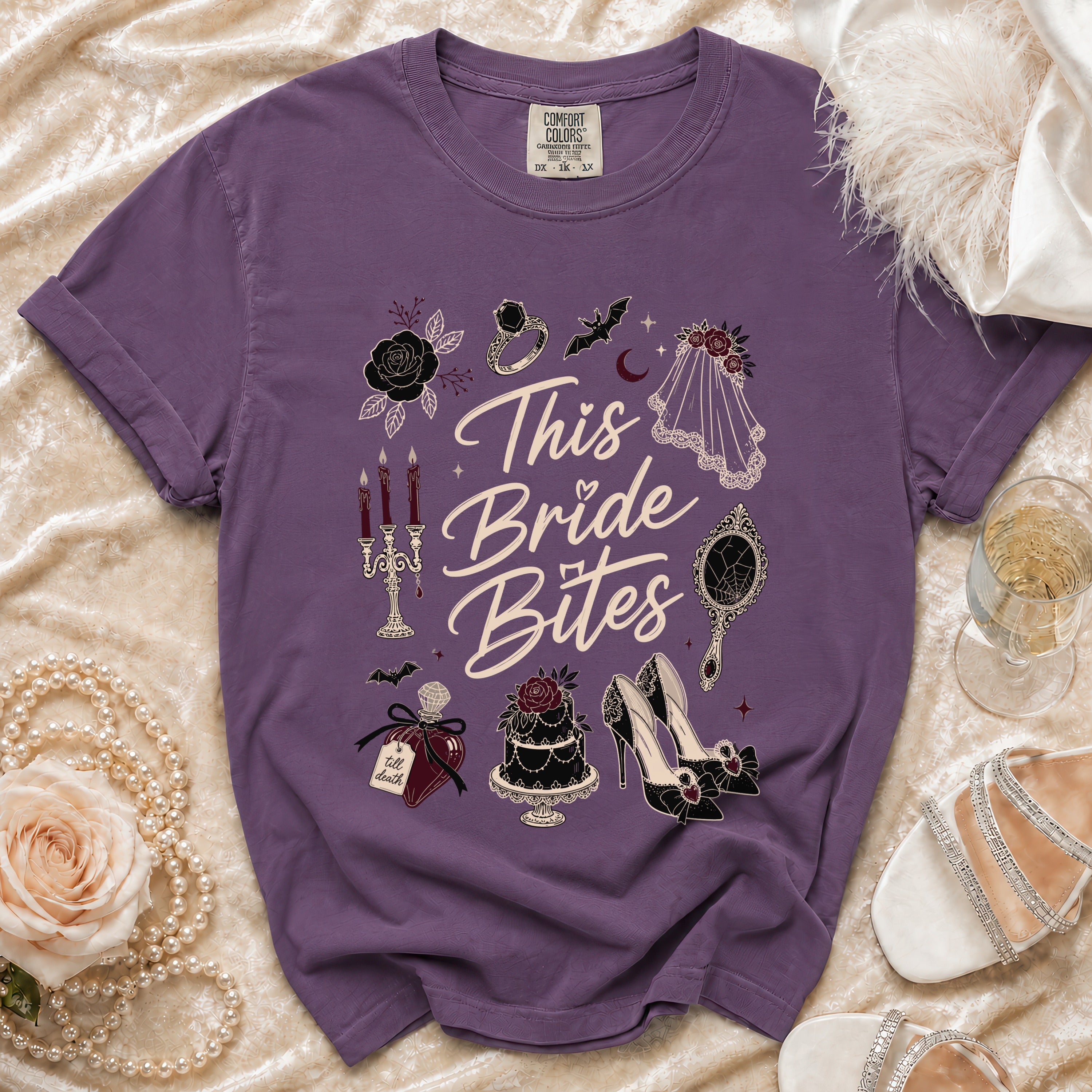 Purple t-shirt with "This Bride Bites" text and gothic wedding-themed graphics.