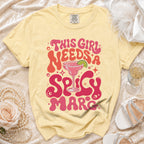 Yellow t-shirt with "This girl needs a spicy marc" text and margarita graphic.