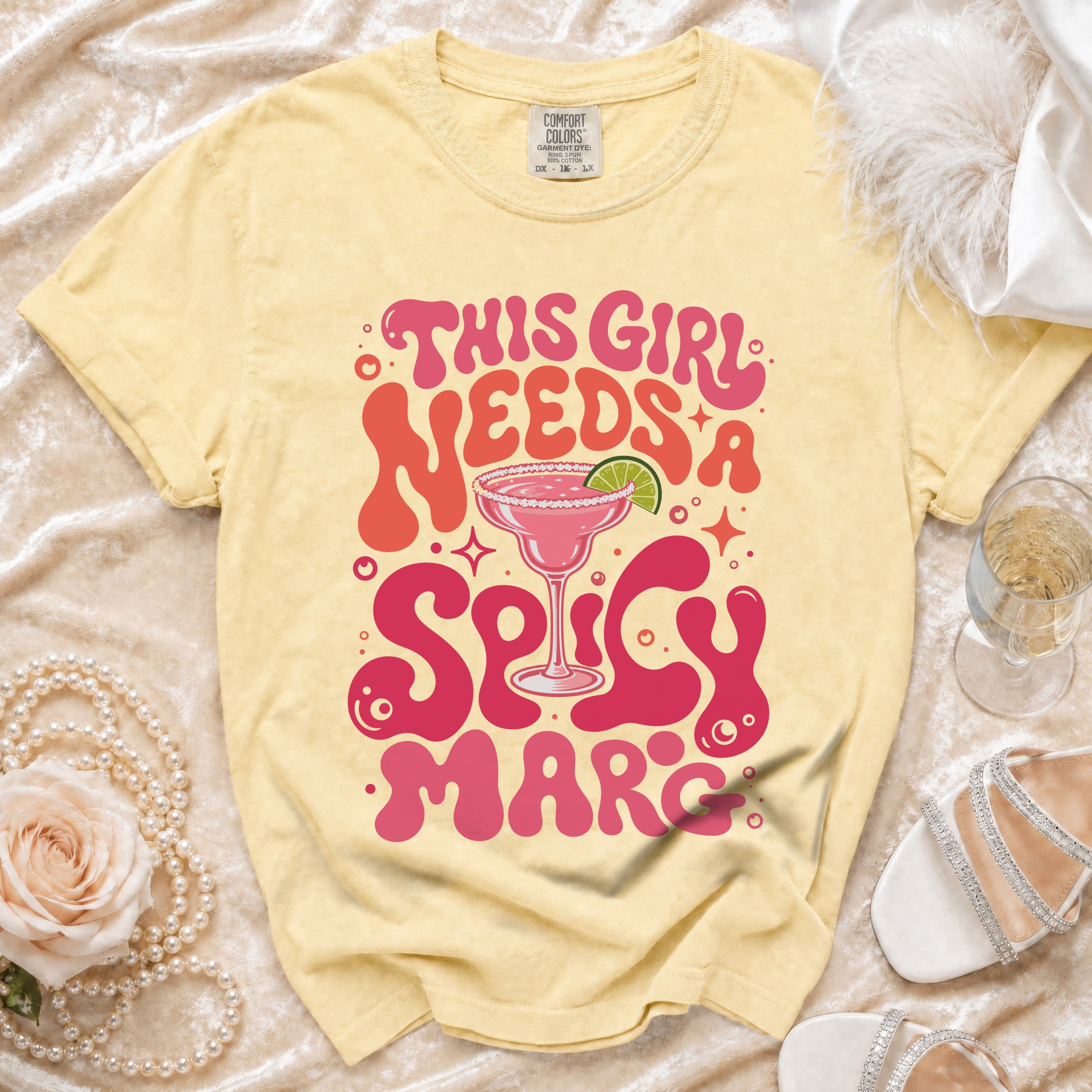 Yellow t-shirt with "This girl needs a spicy marc" text and margarita graphic.