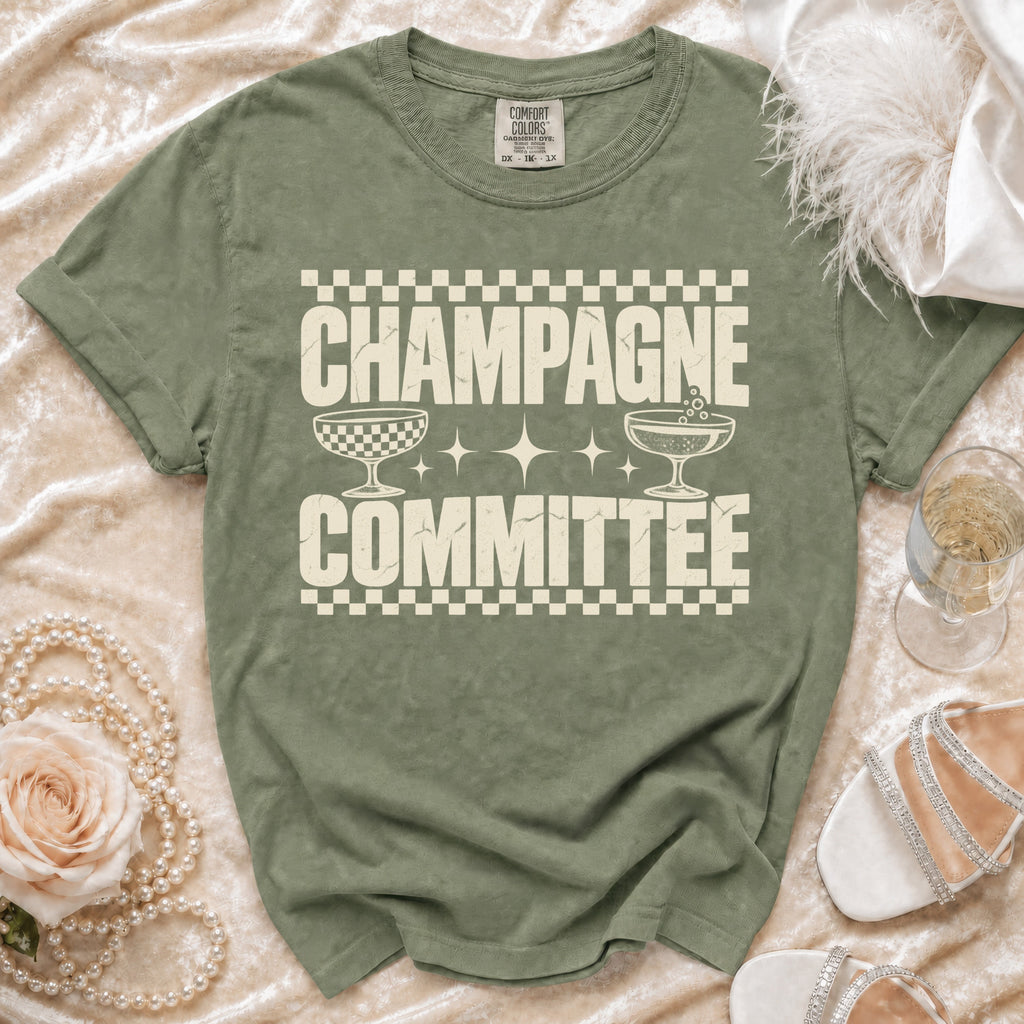 Olive green t-shirt with "CHAMPAGNE COMMITTEE" text and champagne glasses graphic.
