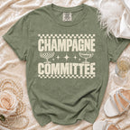Olive green t-shirt with "CHAMPAGNE COMMITTEE" text and champagne glasses graphic.