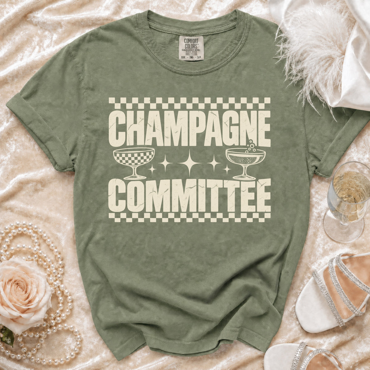 Olive green t-shirt with "CHAMPAGNE COMMITTEE" text and champagne glasses graphic.