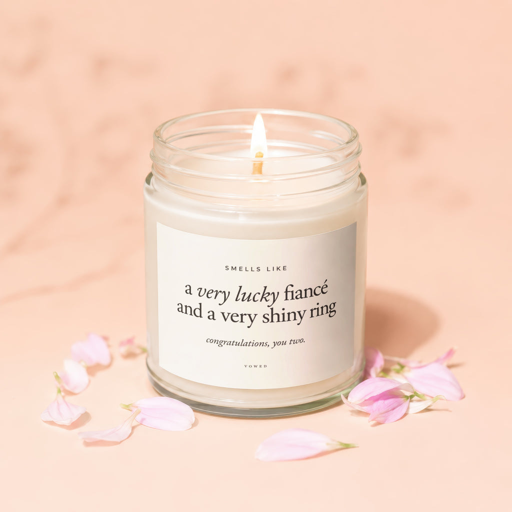 Candle with label "Smells like a very lucky fiancé and a very shiny ring. Congratulations, you two. Vowed."