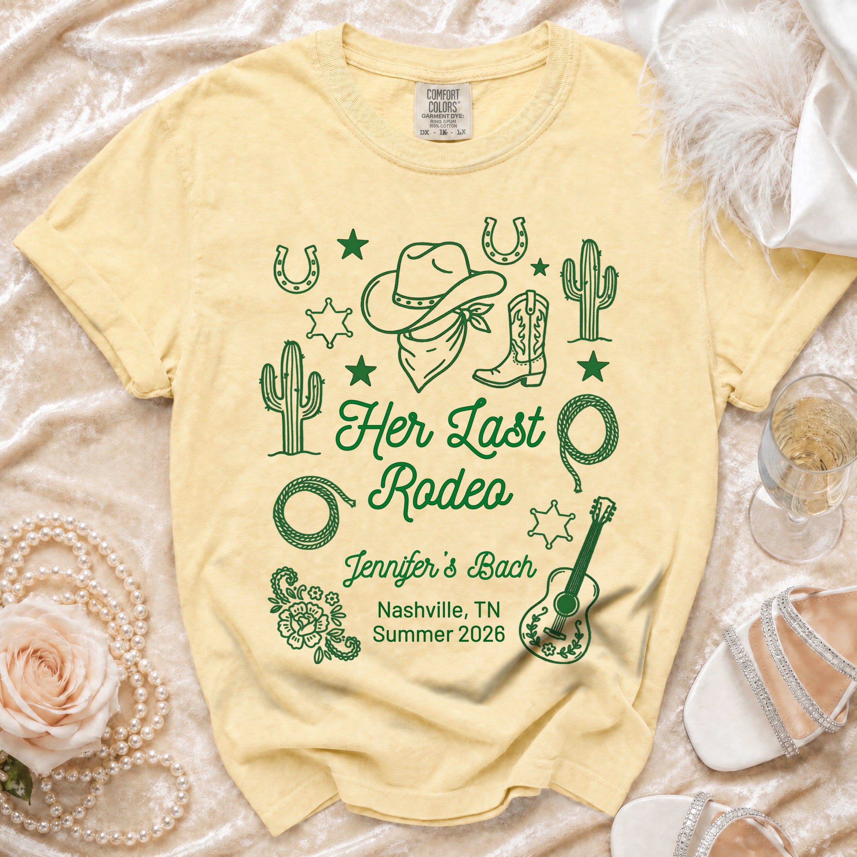 Pale yellow t-shirt with "Her Last Rodeo" graphic, floral, and cowboy elements.