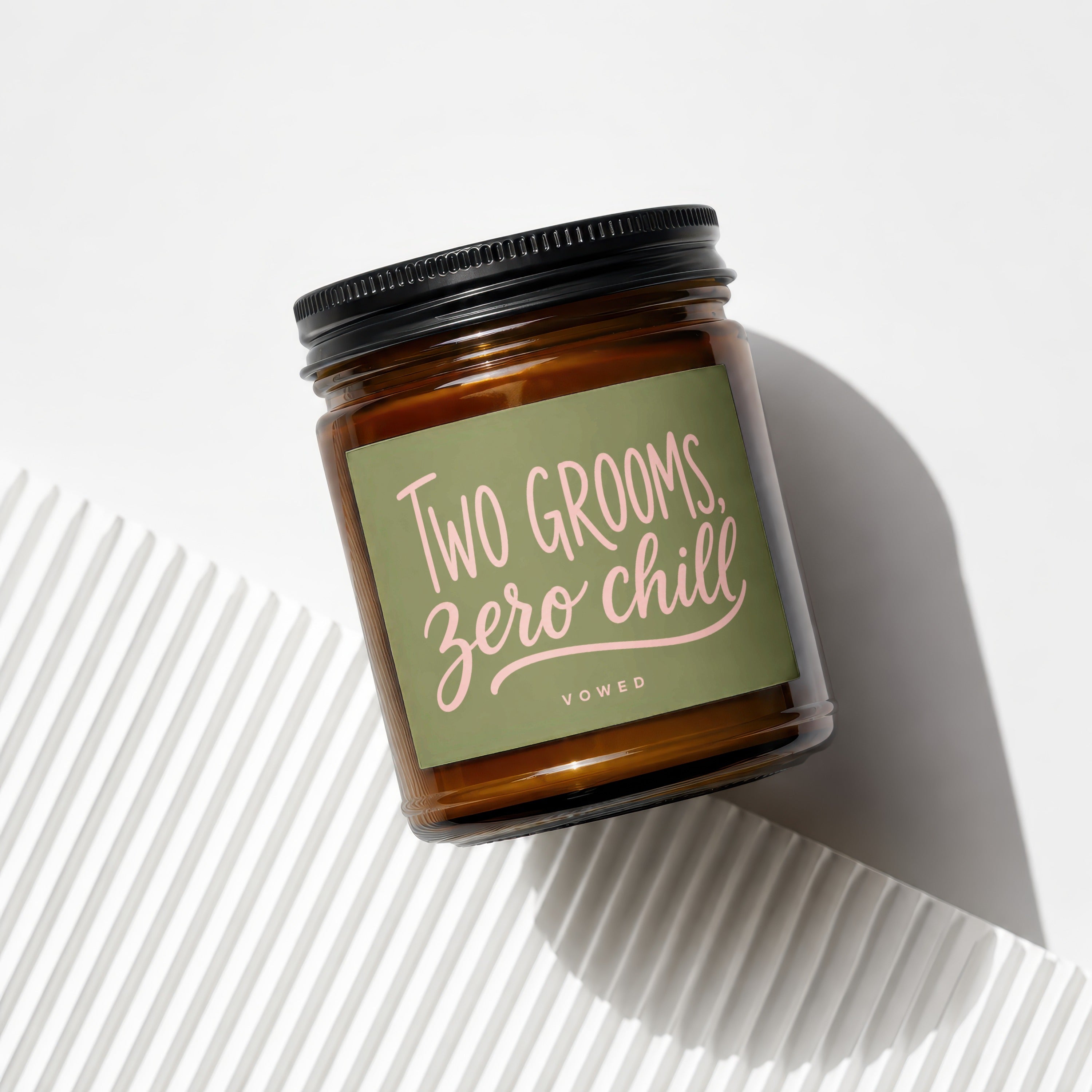 Brown glass jar candle with "Two Grooms, Zero Chill" sentiment and "vowed" text.