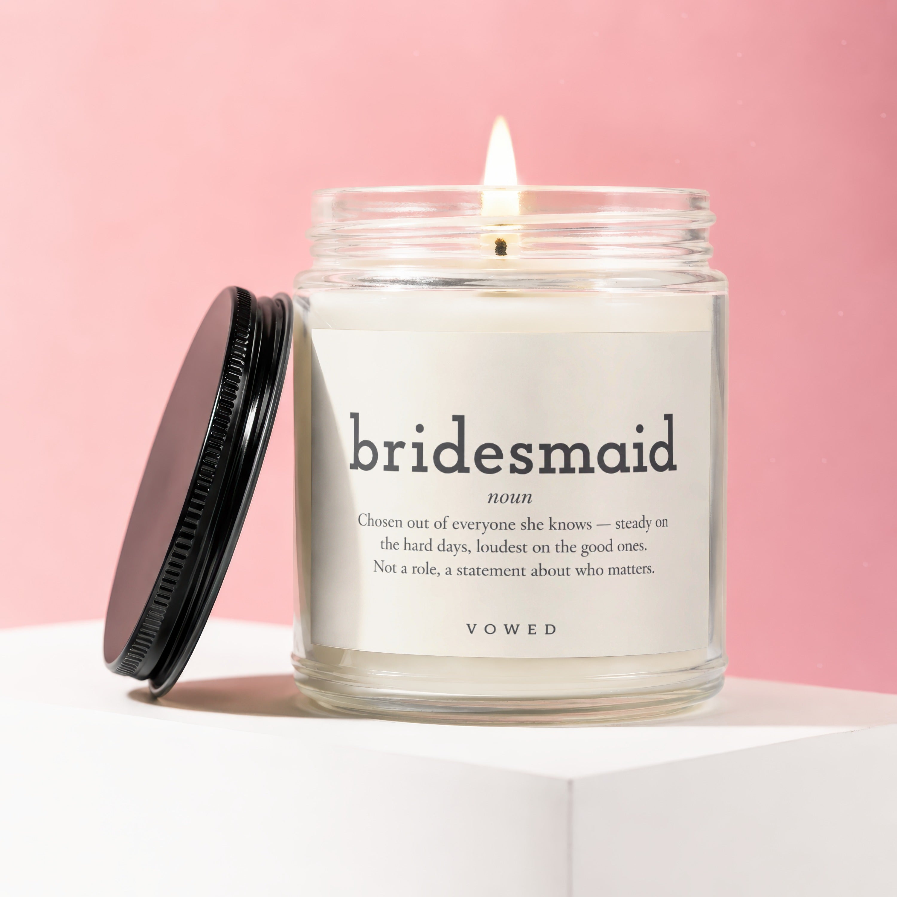 Candle in glass jar with black lid, featuring "bridesmaid" definition label.