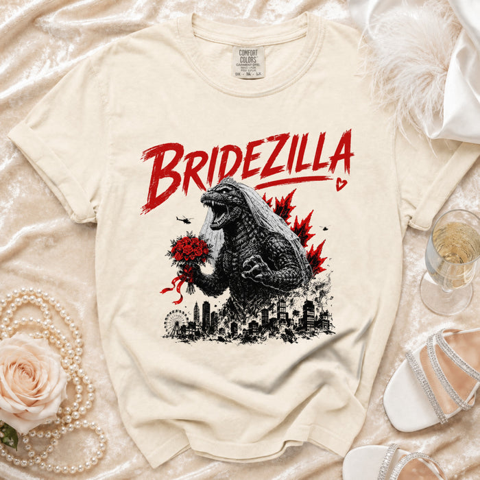 Cream Comfort Colors t-shirt with "BRIDEZILLA" text and Godzilla in a veil holding flowers.