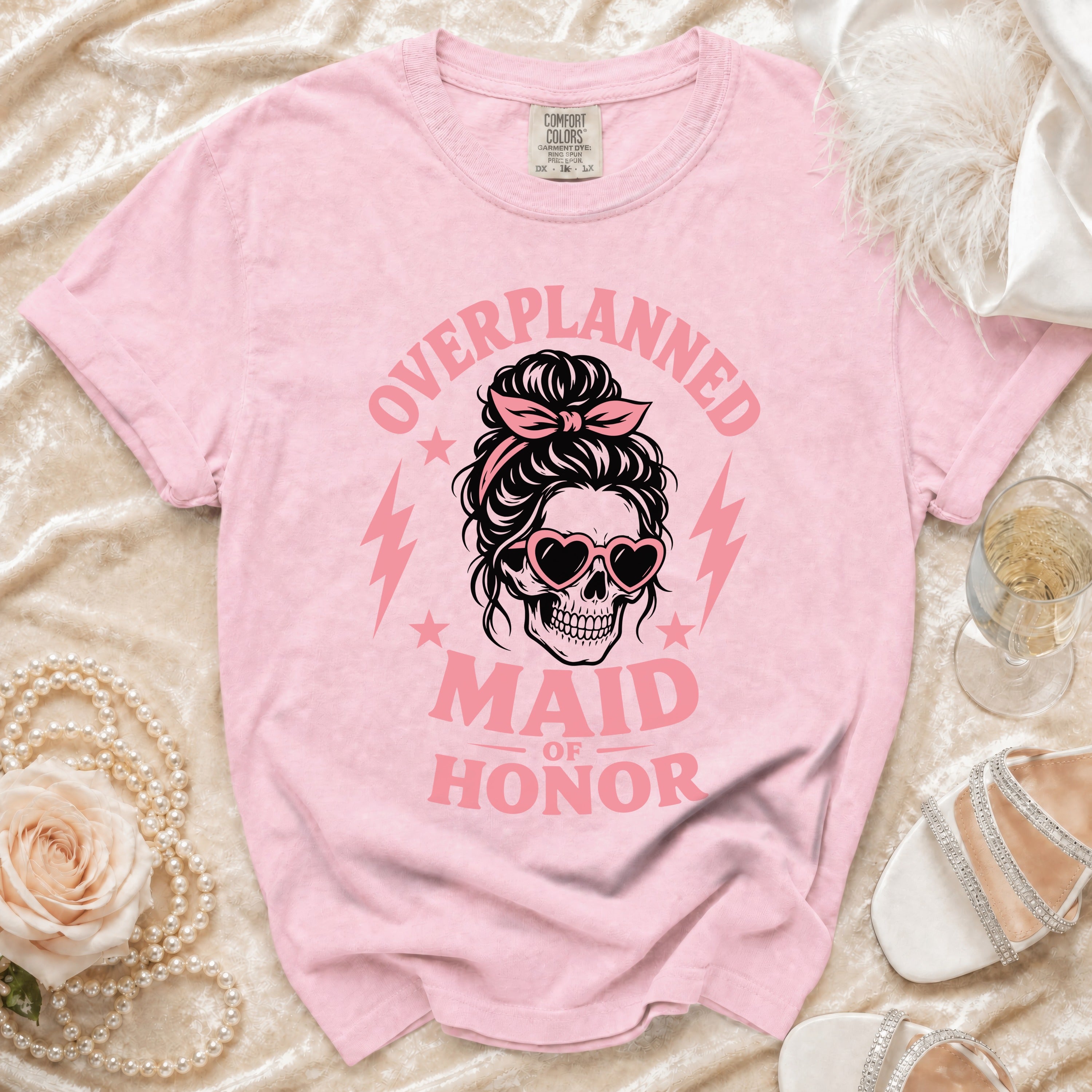 Pink t-shirt with "Overplanned Maid of Honor" text and skull graphic.