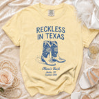Yellow t-shirt with "Reckless in Texas" and cowboy boots.
