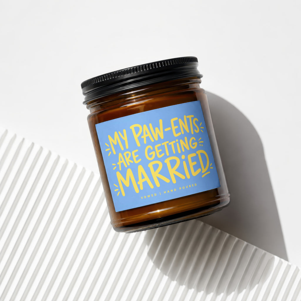 Amber glass candle with a blue label reading "My Paw-ents Are Getting Married".