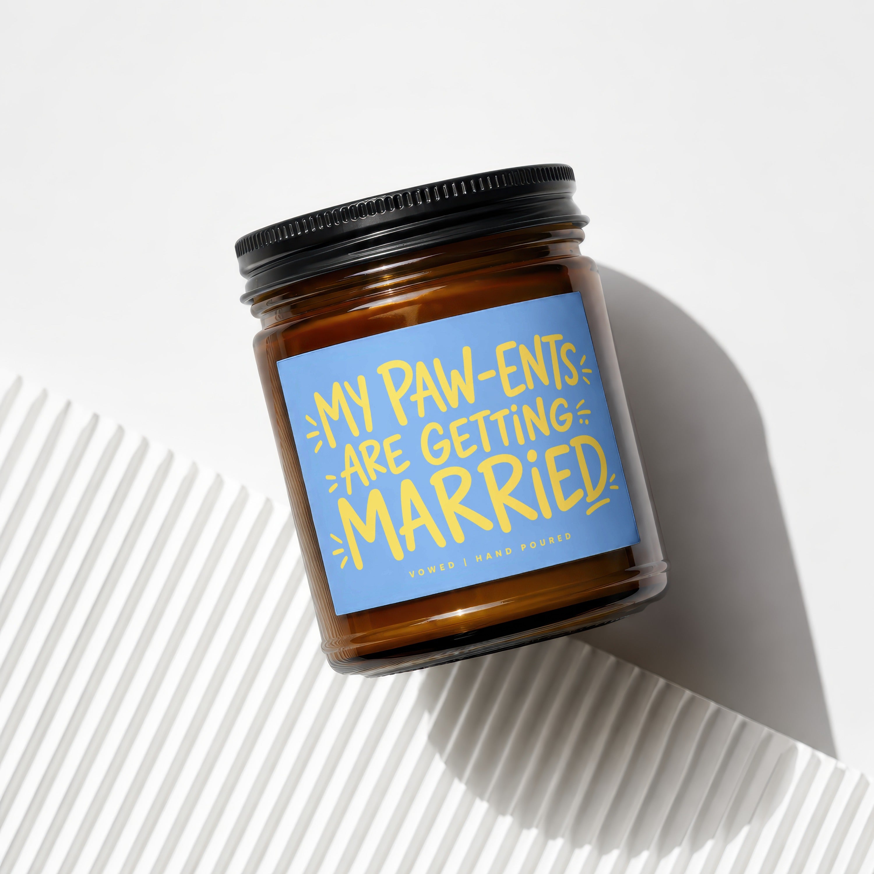 Amber glass candle with a blue label reading "My Paw-ents Are Getting Married".