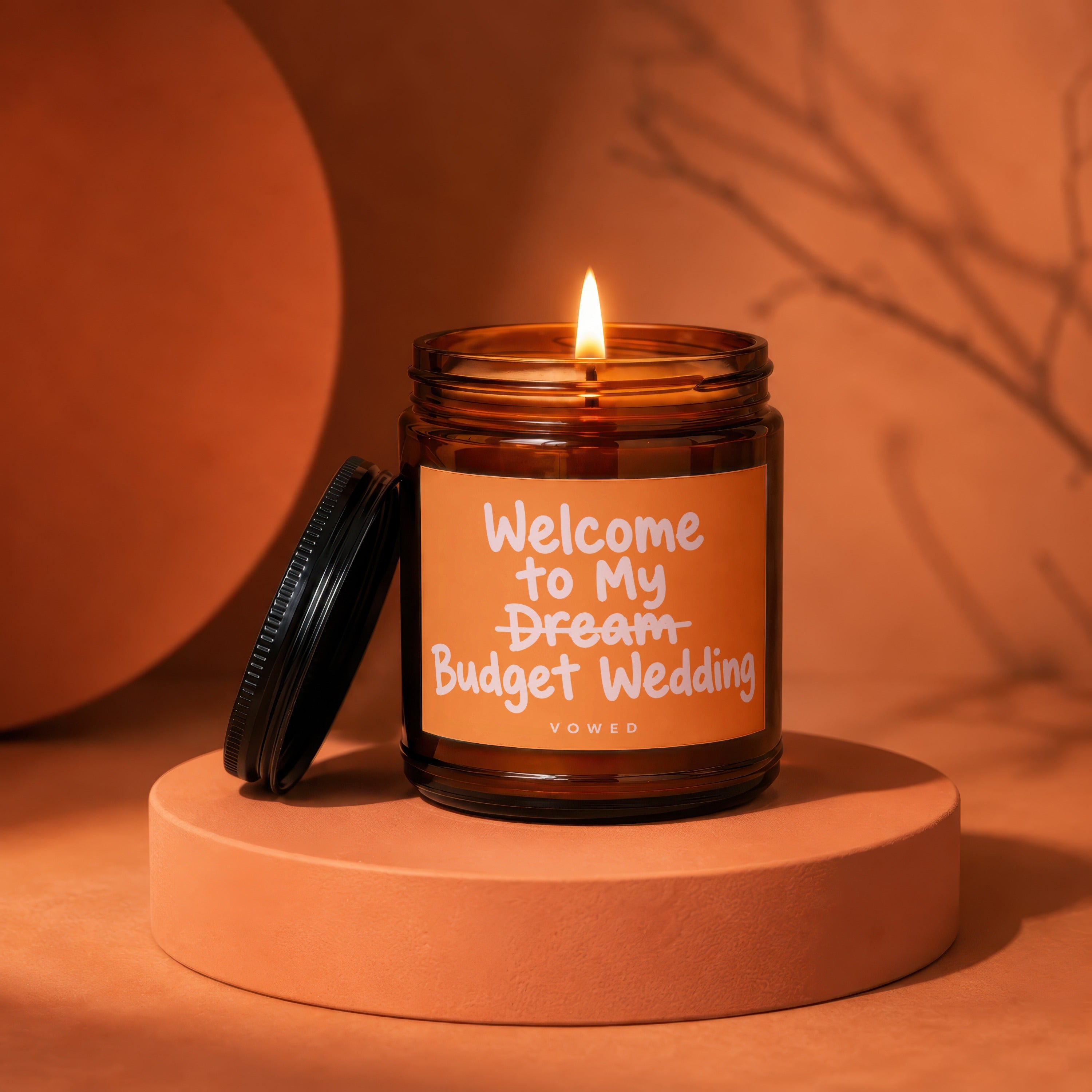 Amber jar candle with lit flame, text reads "Welcome to My Dream Budget Wedding".