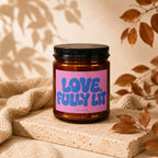 Amber jar candle with pink label reading "LOVE, FULLY LIT" and "VOWED" below.