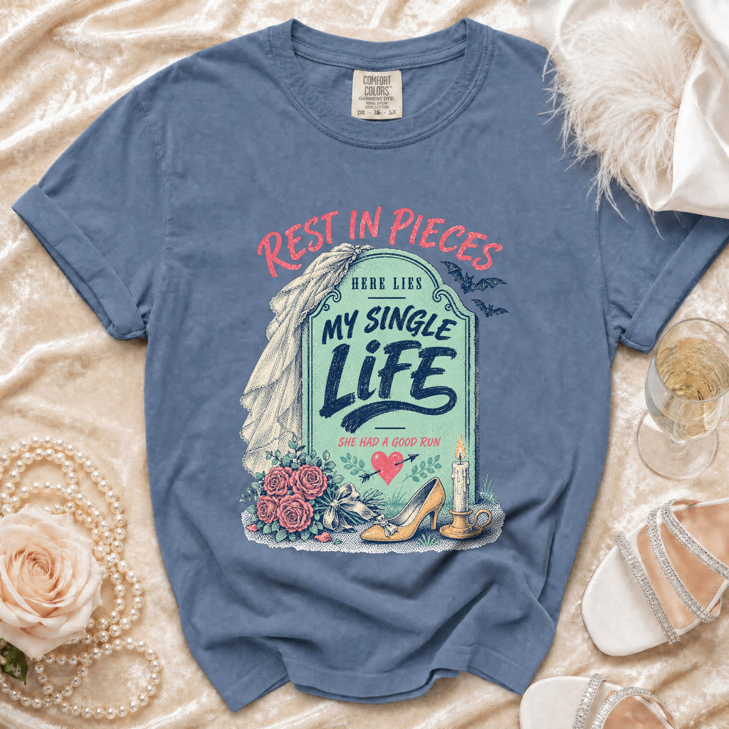 Blue t-shirt with "Rest in Pieces Here Lies My Single Life" tombstone graphic.