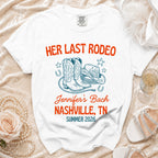 White t-shirt with "Her Last Rodeo Nashville, TN Summer 2026" text and cowboy boots.