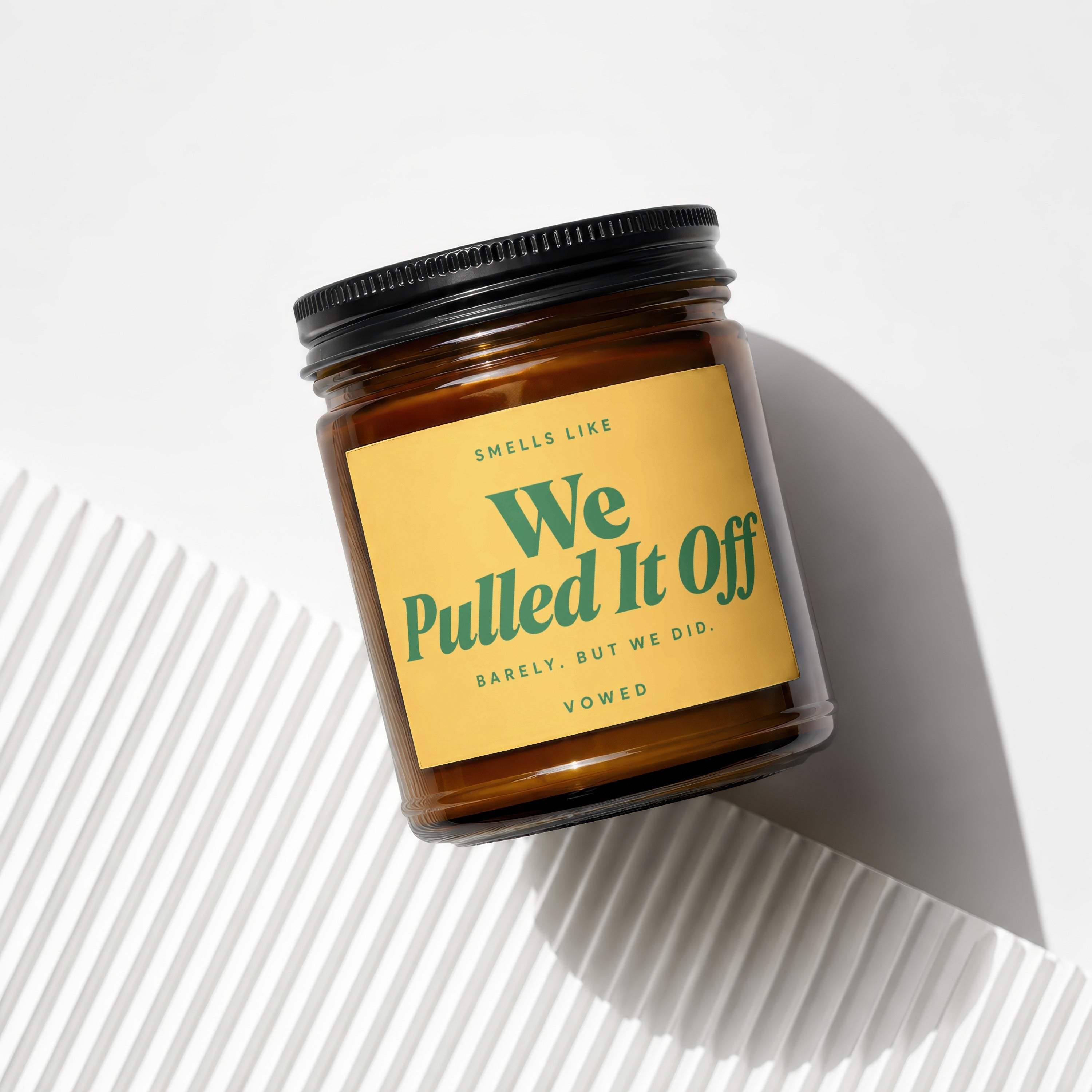 Amber jar candle with yellow label reading "Smells like We Pulled It Off".