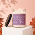 Glass candle with purple label reading "Love, Laughter & Happily Ever After VOWED".