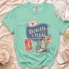 Comfort Colors t-shirt with "Reckless in Texas" graphic and disco cowgirl boot.