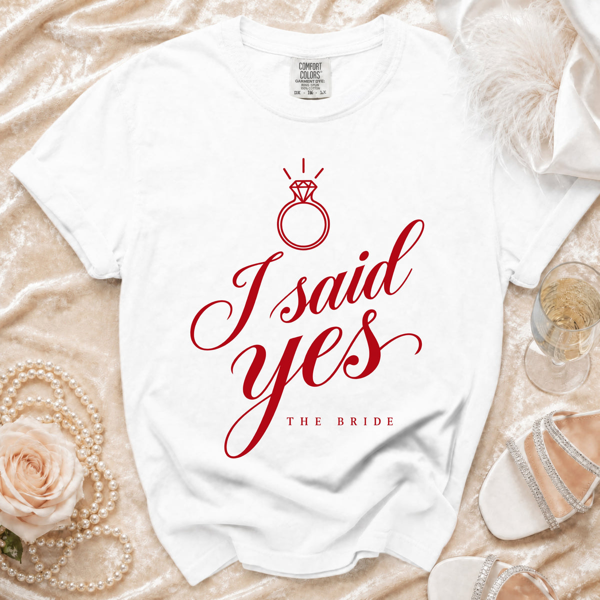 White t-shirt with red text "I said yes THE BRIDE" and diamond ring graphic.