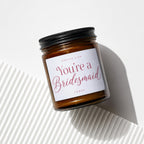 Amber candle with black lid, labeled "Smells like You're a Bridesmaid".