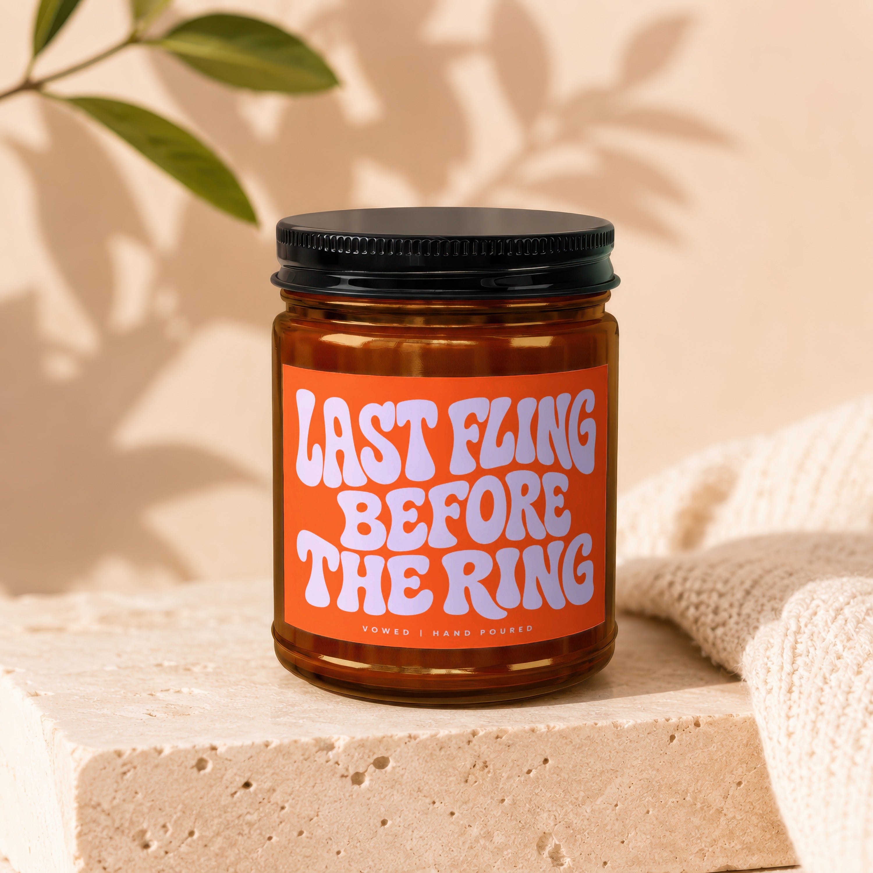 Amber candle in glass jar with orange label that reads "LAST FLING BEFORE THE RING".