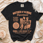 Black t-shirt with "Mother of the Bride Department" text and cartoon graphic.