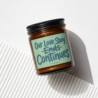 Candle with label "Our Love Story Ends Continues" and "vowed".