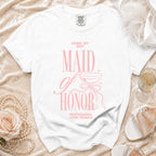 White t-shirt with pink text "MAID OF HONOR" and "PROFESSIONAL HYPE WOMAN".