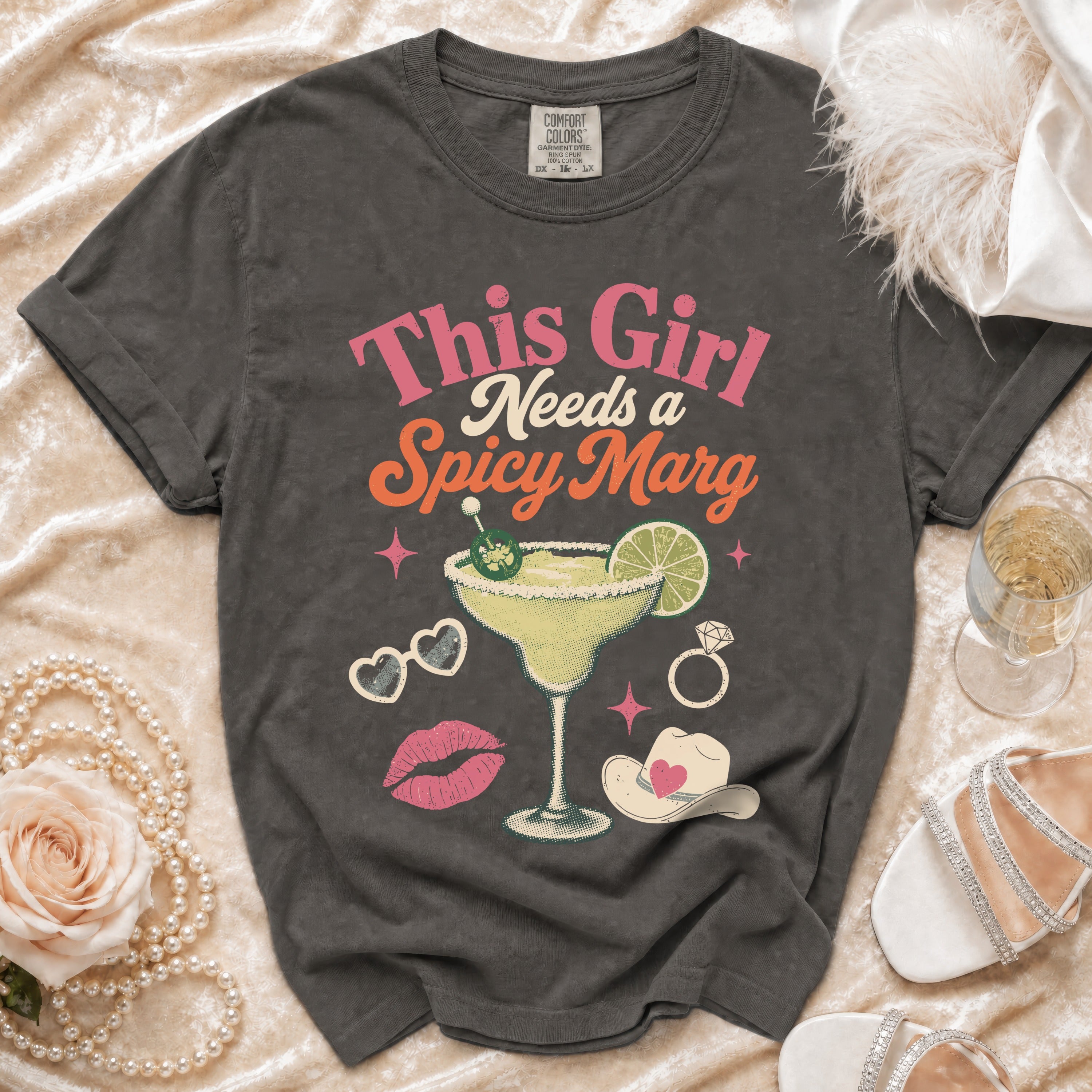 Graphic t-shirt with text "This Girl Needs a Spicy Marg" and margarita image.