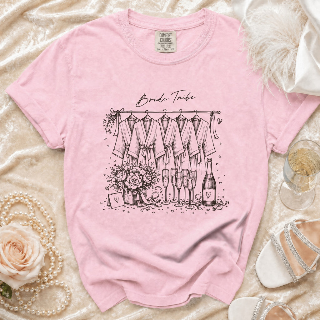 Pink t-shirt with "Bride Tribe" and sketch of robes, flowers, champagne, and bottle.