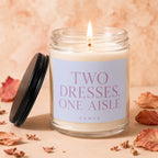 Candle with "Two Dresses, One Aisle" text and a lit wick.
