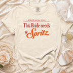Cream t-shirt with "Spritz Social Club" and "This Bride needs a Spritz" in red.