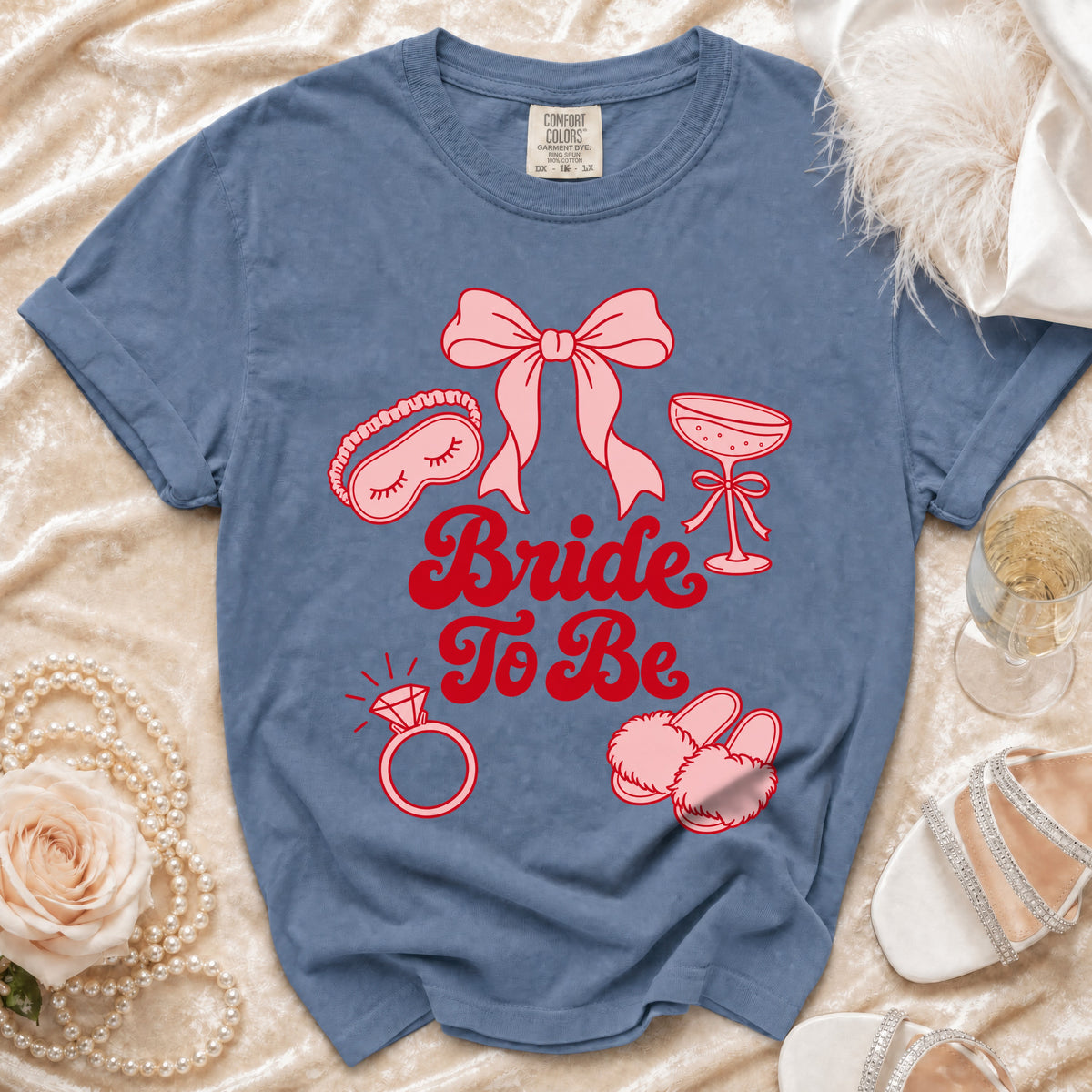 Blue t-shirt with pink "Bride To Be" text and bridal icons.
