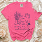 Pink t-shirt with "Holding Her Dress and Her Secrets" and graphic.
