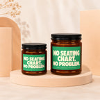 Two amber glass candles with green labels that read "NO SEATING CHART. NO PROBLEM."