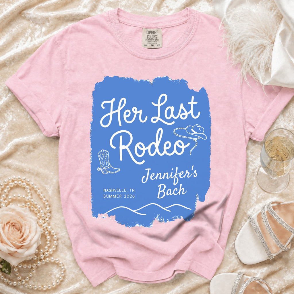 Pink t-shirt with "Her Last Rodeo" text, cowboy boots, and hat.