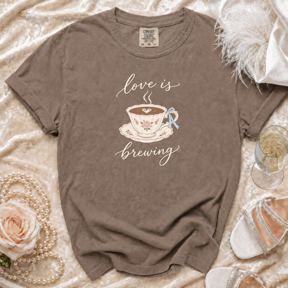 Brown Comfort Colors t-shirt with "love is brewing" and teacup graphic.