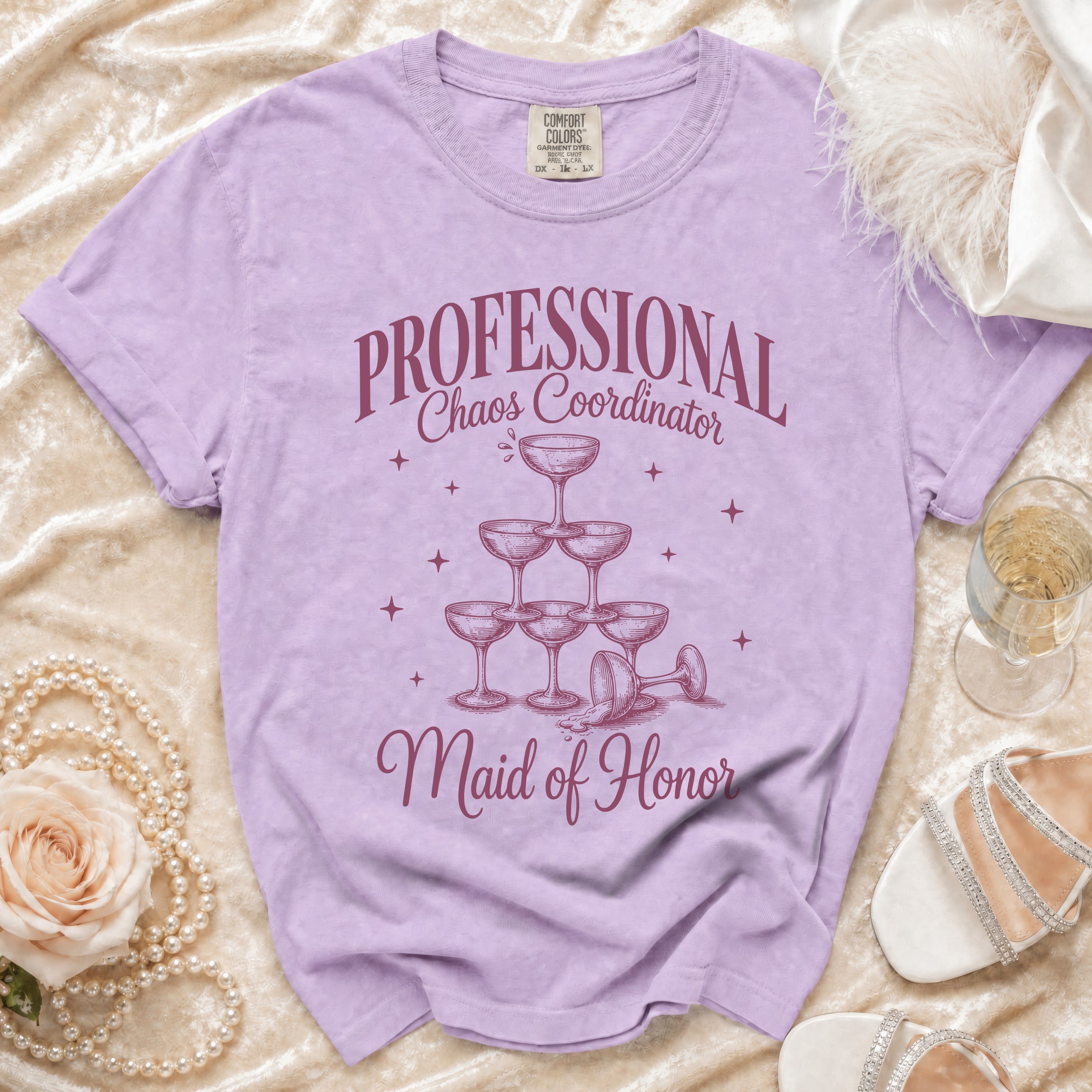 Purple t-shirt with "PROFESSIONAL Chaos Coordinator Maid of Honor" text and champagne glasses.