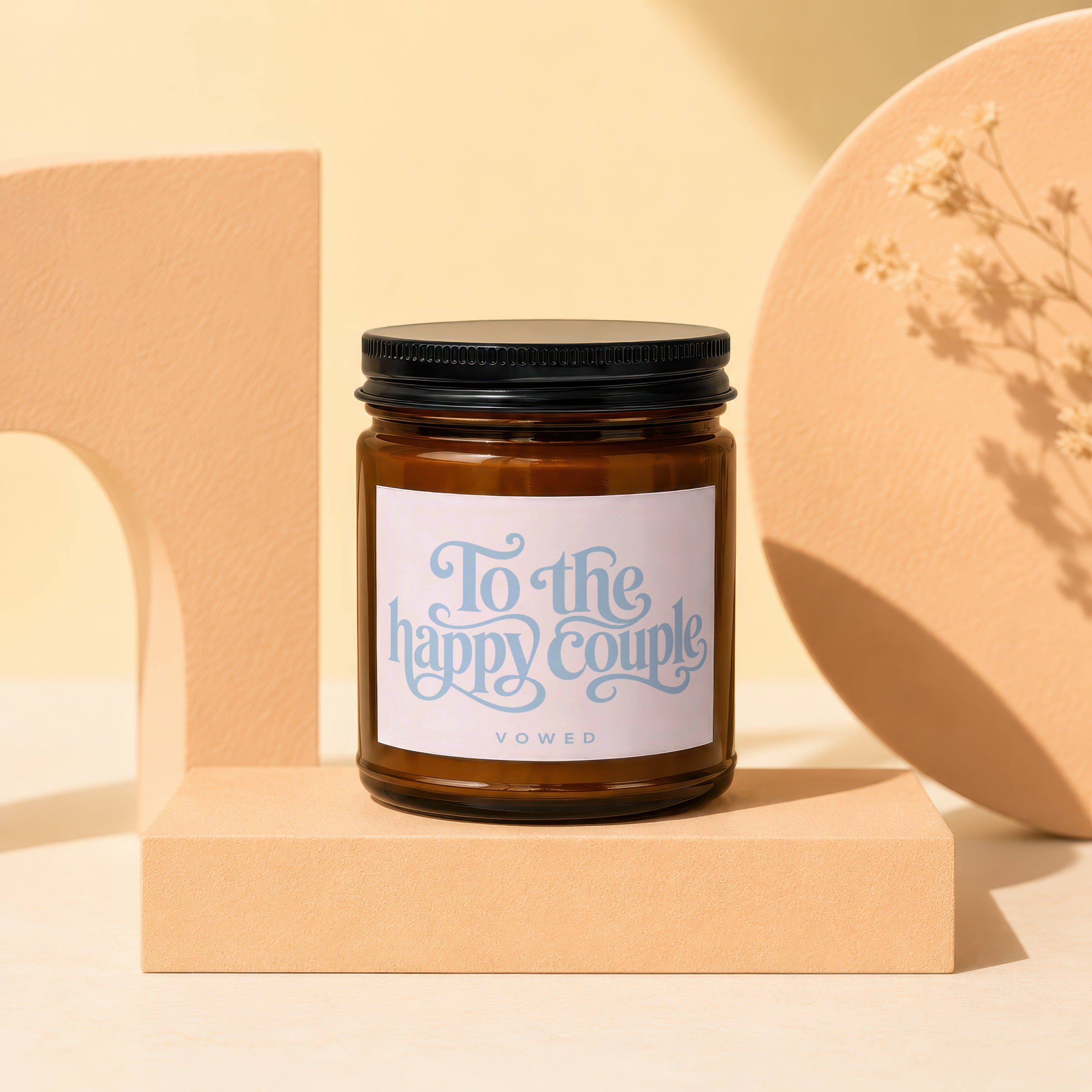 Brown glass candle with a white label reading "To the happy couple VOWED".
