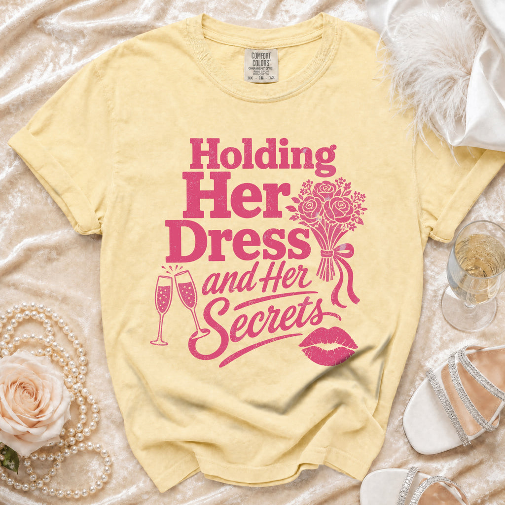 Yellow t-shirt with "Holding Her Dress and Her Secrets" graphic and accompanying icons.